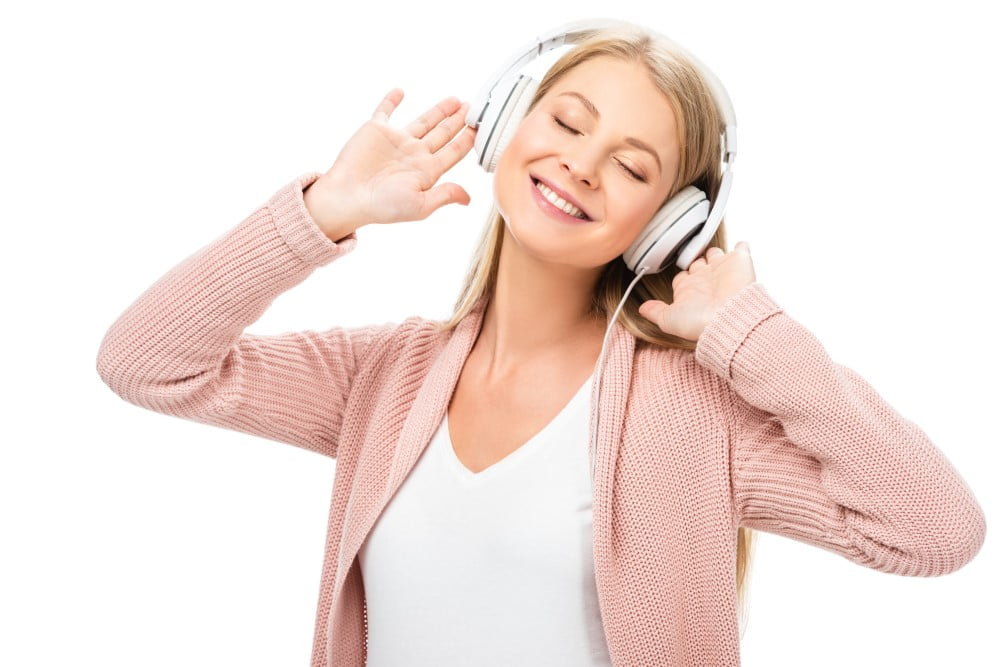 Kvinde i cardigan som hører musik